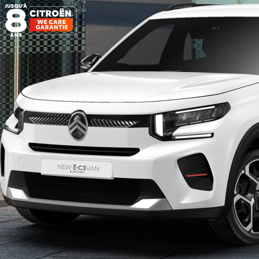 Vista frontal tres cuartos del Citroën ë-C3 Comercial aparcado en un entorno urbano, destacando su diseño moderno y sus proporciones compactas.