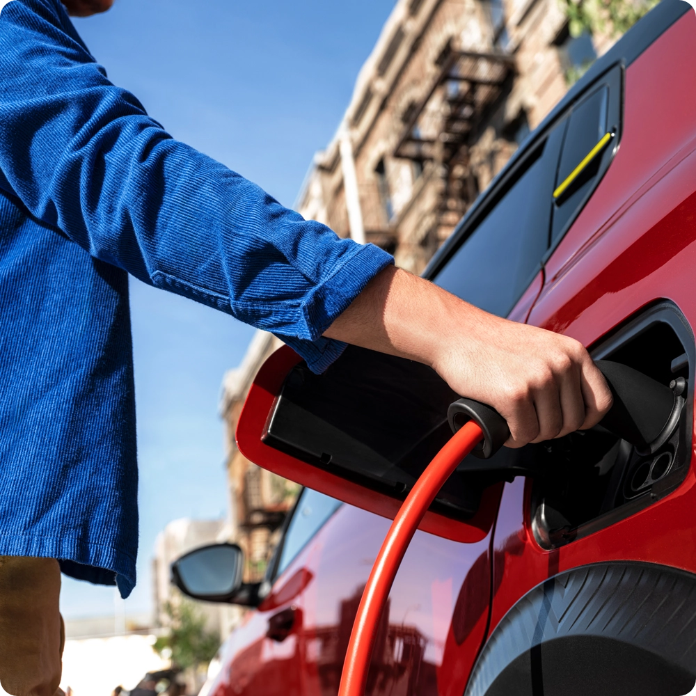 Vista de detalle del puerto de carga del Citroën ë-C3 Comercial conectado a un cable de carga, destacando la carga eléctrica práctica y la movilidad de cero emisiones.