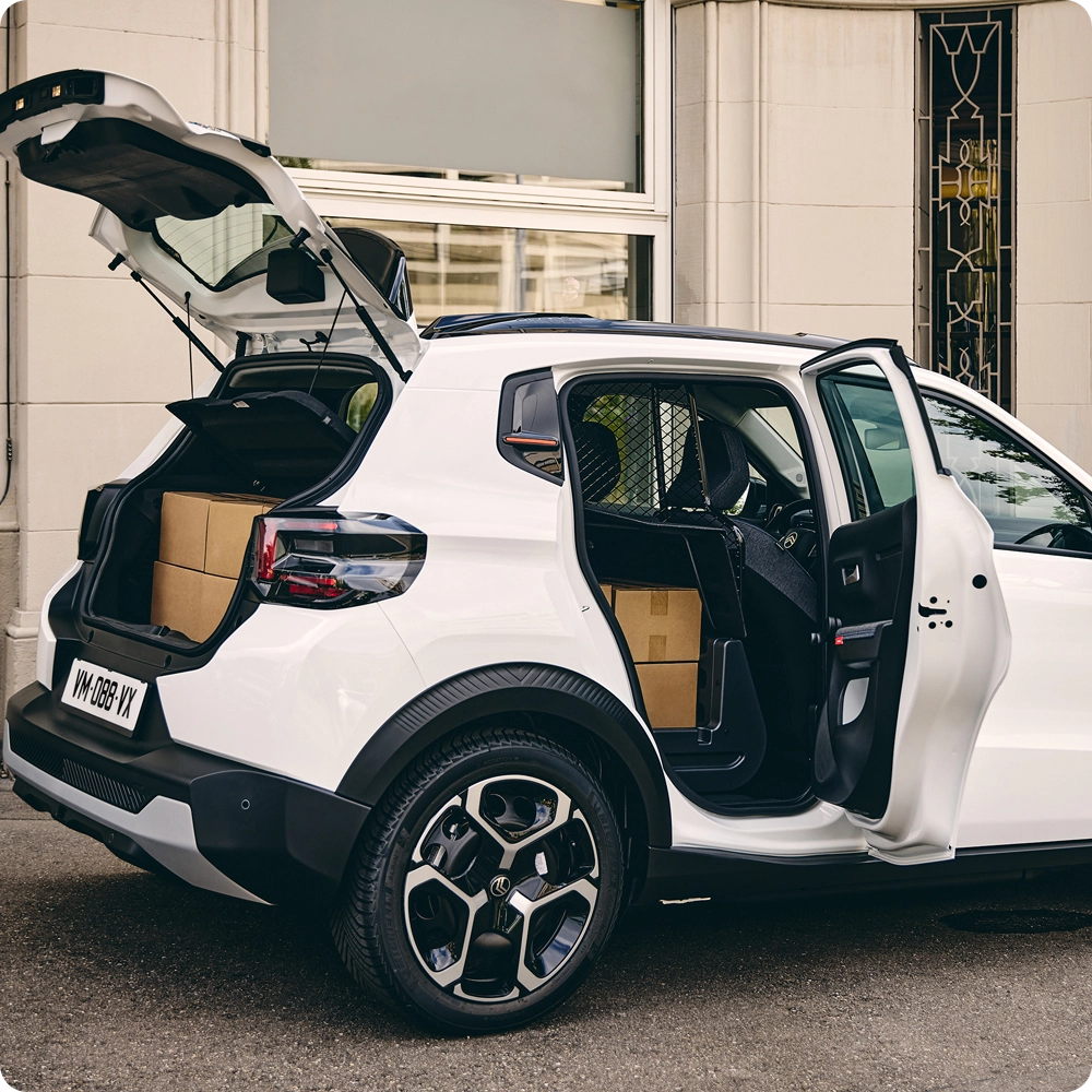 Vista trasera tres cuartos del Citroën ë-C3 Comercial con el portón y la puerta lateral abiertos, destacando la accesibilidad de carga, las soluciones de carga versátiles y el estilo inspirado en los SUV.