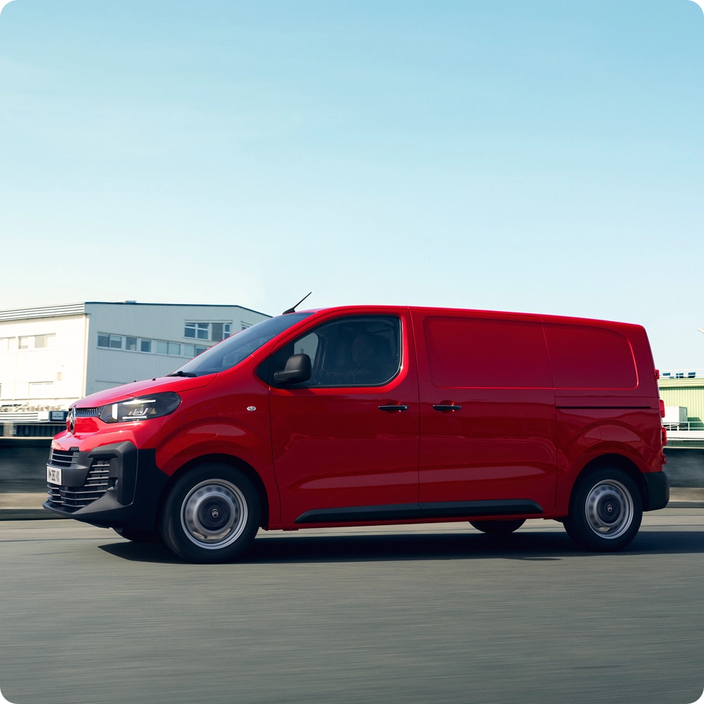 Vista exterior lateral de un Citroën ë-Jumpy rojo circulando por carretera, mostrando autonomía eléctrica, practicidad diaria y presencia profesional segura.