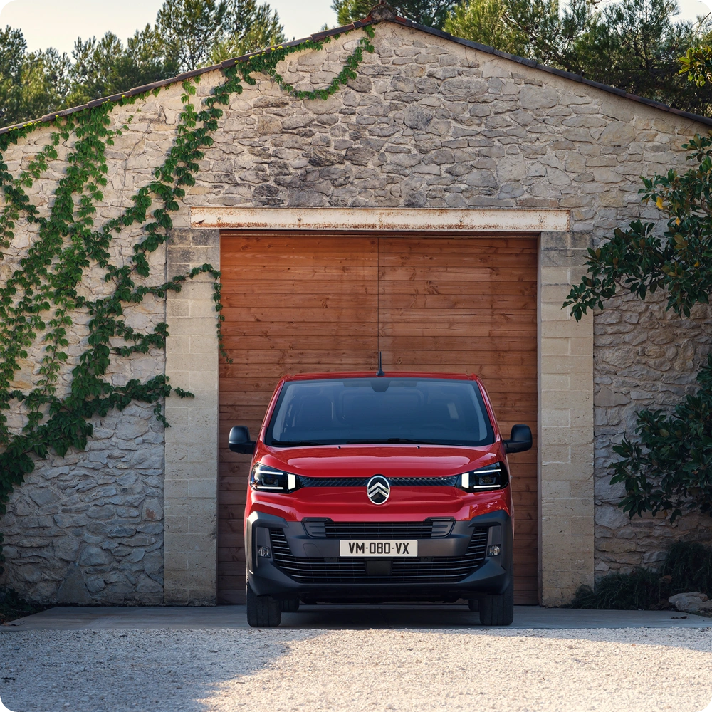 Vista exterior frontal de un Citroën Jumpy rojo aparcado frente a un edificio, mostrando diseño profesional, robustez, practicidad y presencia segura.