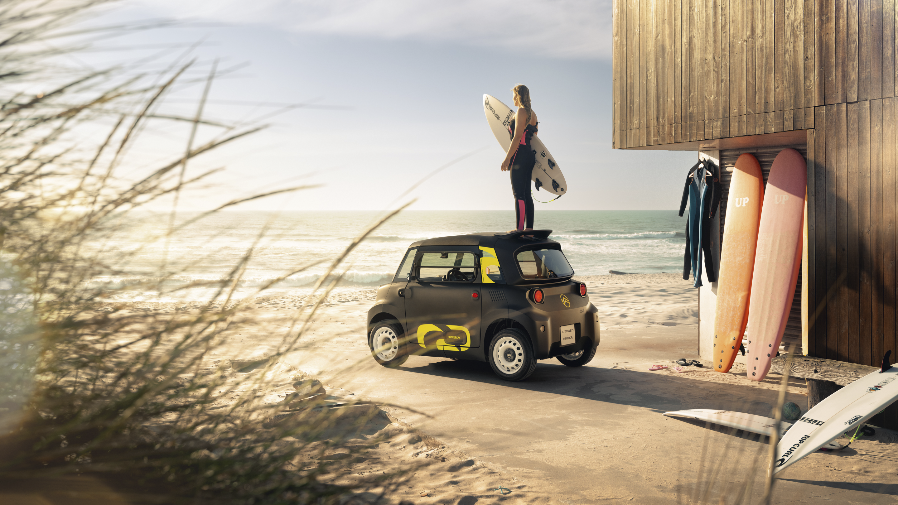 Vista lifestyle trasera playa del Citroën Ami x Rip Curl eléctrico sin carné, libertad surf Citroën Ami para coche eléctrico urbano