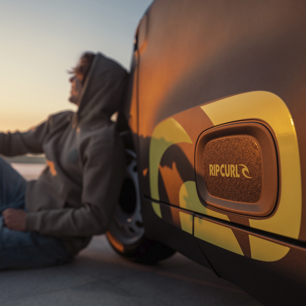 Vista detalle emblema lateral del Citroën Ami x Rip Curl eléctrico sin carné, firma Citroën Ami Rip Curl para coche eléctrico urbano