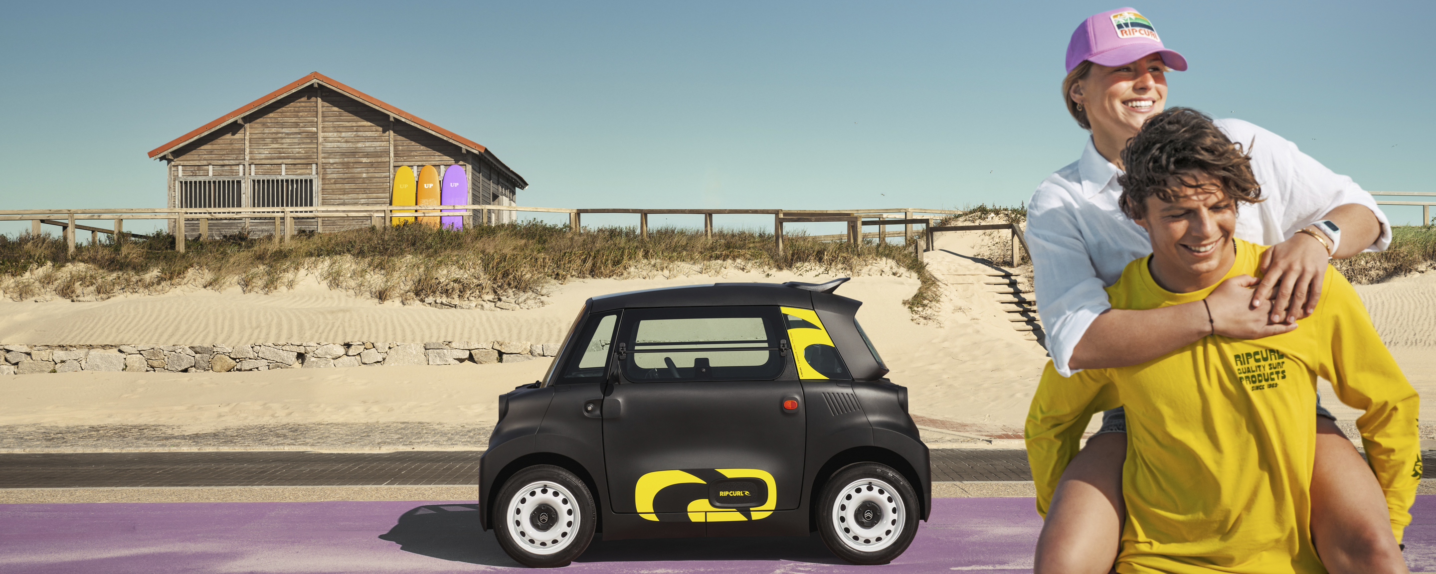 Vista lifestyle lateral del Citroën Ami x Rip Curl eléctrico sin carné, libertad junto al mar Citroën Ami para coche eléctrico urbano