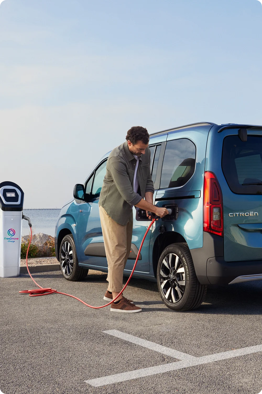 Vista lateral del ë‑Berlingo cargando en una estación Free2move mostrando seguridad, eficiencia, tecnología y con confianza eléctrico uso