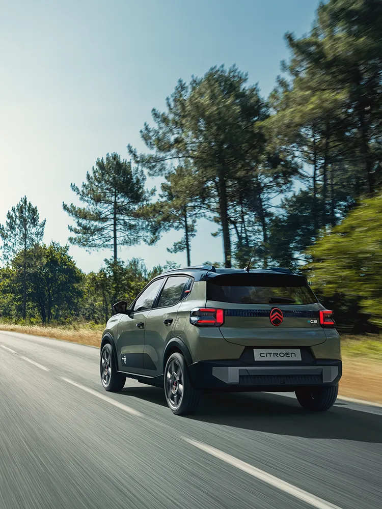 Vista trasera en tres cuartos del Citroën ëC3 Outdoor, con pilotos LED y Advanced Comfort, circulando por carretera abierta