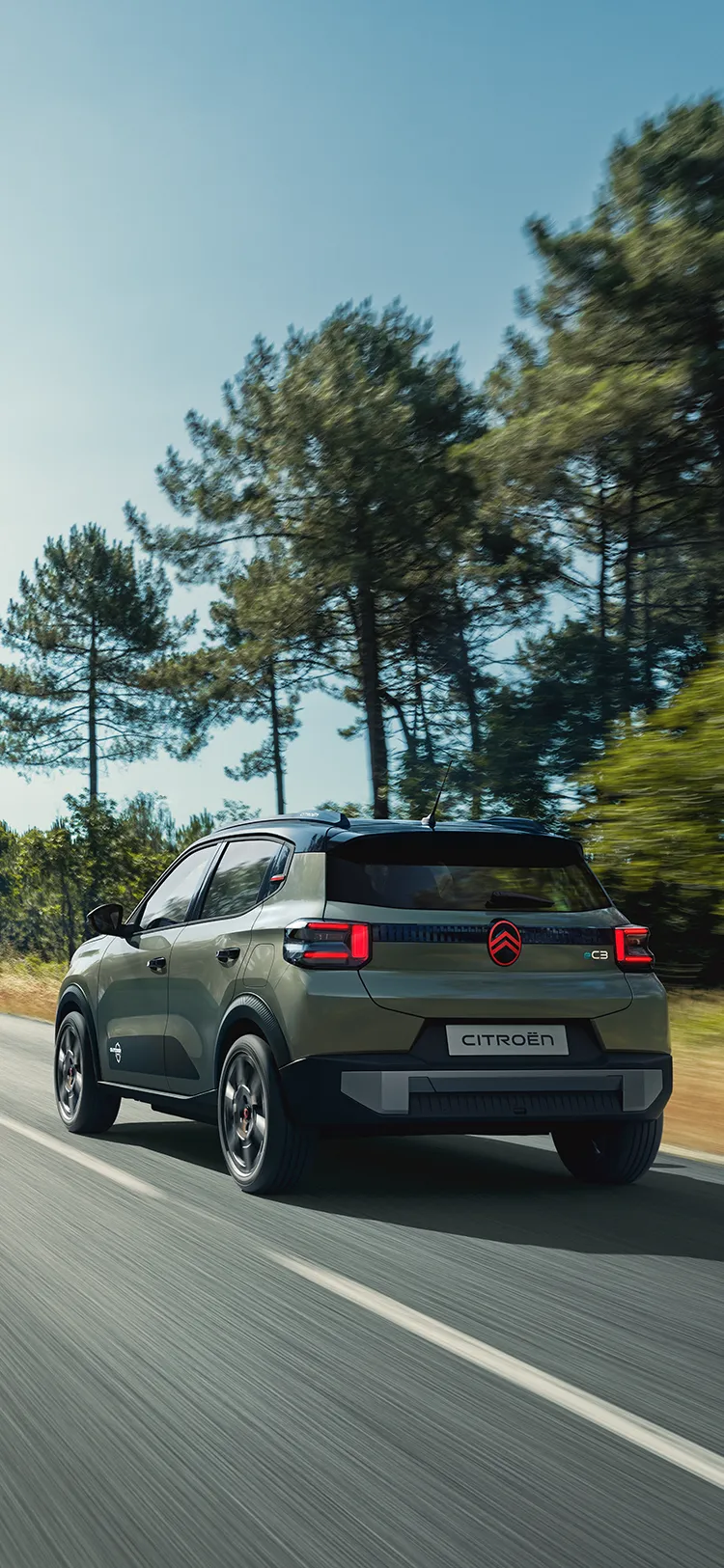 Vista trasera en tres cuartos del Citroën C3 Outdoor, con pilotos LED y Advanced Comfort, en carretera abierta