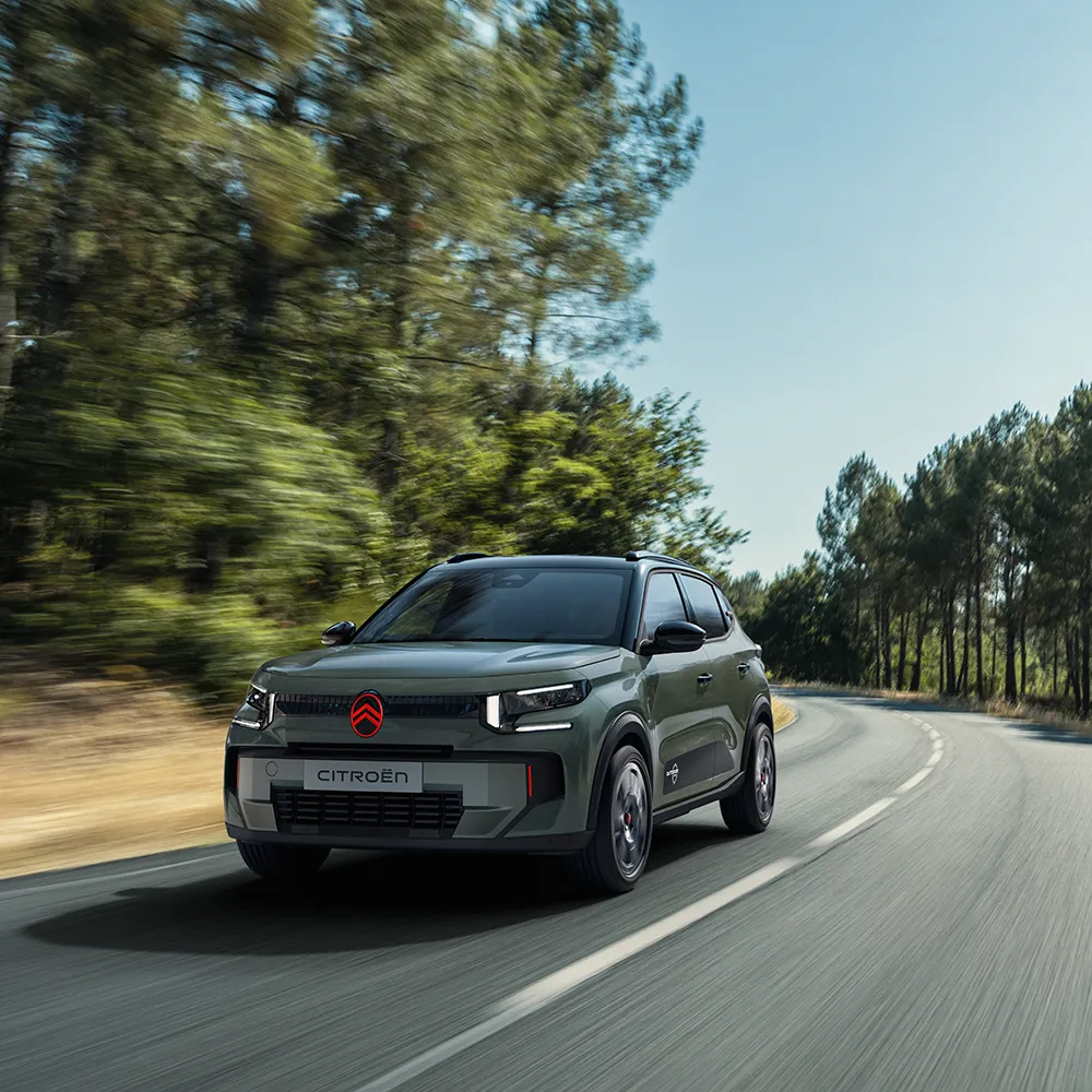 Vista frontal en tres cuartos del Citroën C3 Outdoor con firma luminosa LED y Citroën Advanced Comfort durante un recorrido por un entorno natural
