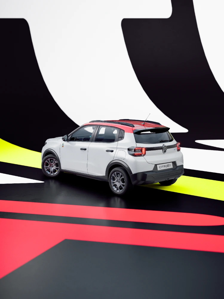 Vista tres cuartos trasera del Citroën ë-C3 TONIC edición limitada, coche eléctrico urbano con fondo gráfico atrevido y diseño compacto, alternativa electrica inteligente