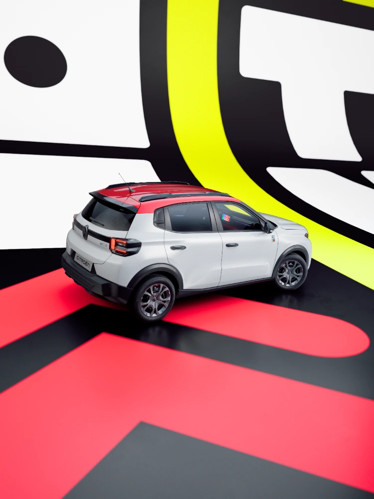 Vista tres cuartos trasera del Citroën ë-C3 TONIC edición limitada, coche eléctrico urbano con diseño atrevido en ambiente de estudio, alternativa electrica inteligente
