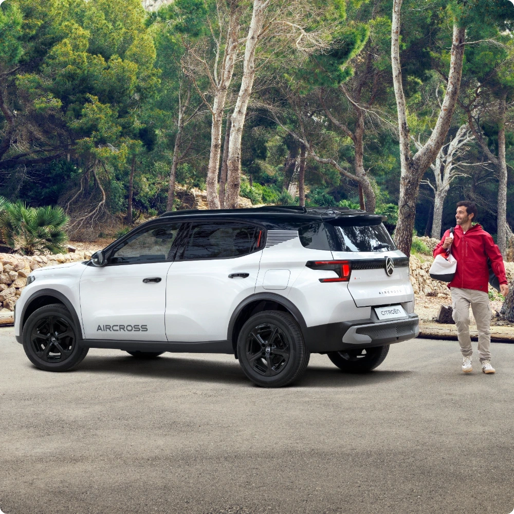 Vista trasera en tres cuartos exterior en movimiento del Citroën C3 Aircross Hybrid SUV mostrando tecnología híbrida eficiente para una movilidad diaria fluida, económica y asequible.