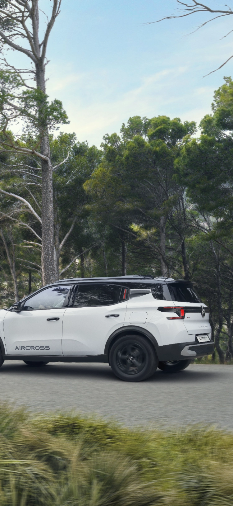 Vista trasera en tres cuartos en movimiento del Citroën C3 Aircross SUV en un sendero forestal destacando un rendimiento robusto para una movilidad versátil, segura y asequible.