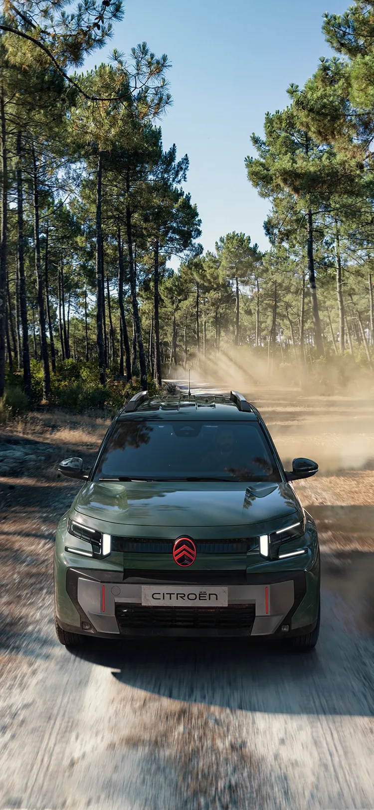 Vista frontal aérea del Citroën C3 Aircross SUV en un sendero forestal, con firma luminosa LED y Advanced Comfort
