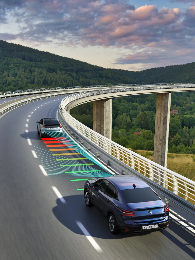 Vista lateral en conducción del Citroën C4 X mostrando Reconocimiento de Límites de Velocidad para una conducción más segura e informada.