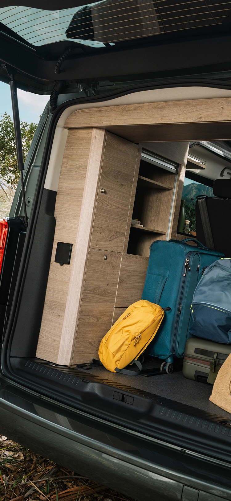 Maletero abierto de la furgoneta camper Citroën mostrando un espacio de almacenamiento bien organizado con equipaje y material