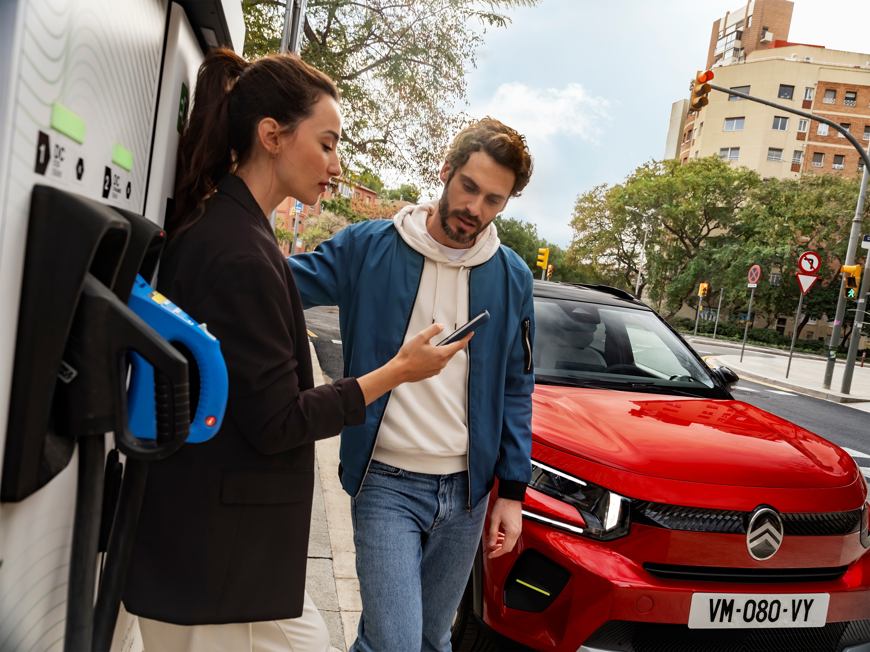 Vista de carga en la calle del Citroën C3 SUV con personas preparando la carga rápida para una movilidad urbana conveniente, eficiente y asequible.