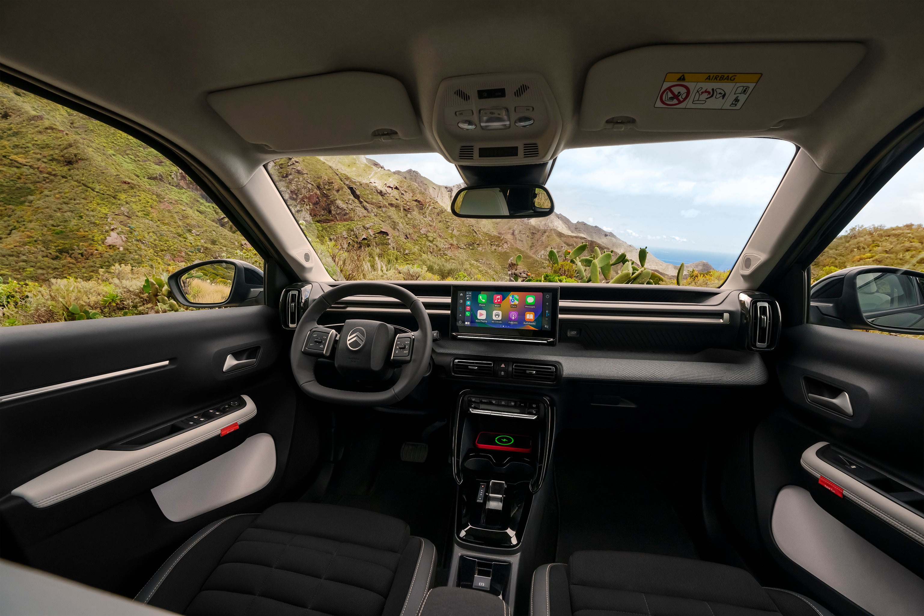 Vista interior frontal del Citroën ë-C3 Aircross SUV mostrando salpicadero panorámico y gran pantalla táctil para una conducción diaria intuitiva, espaciosa y asequible.