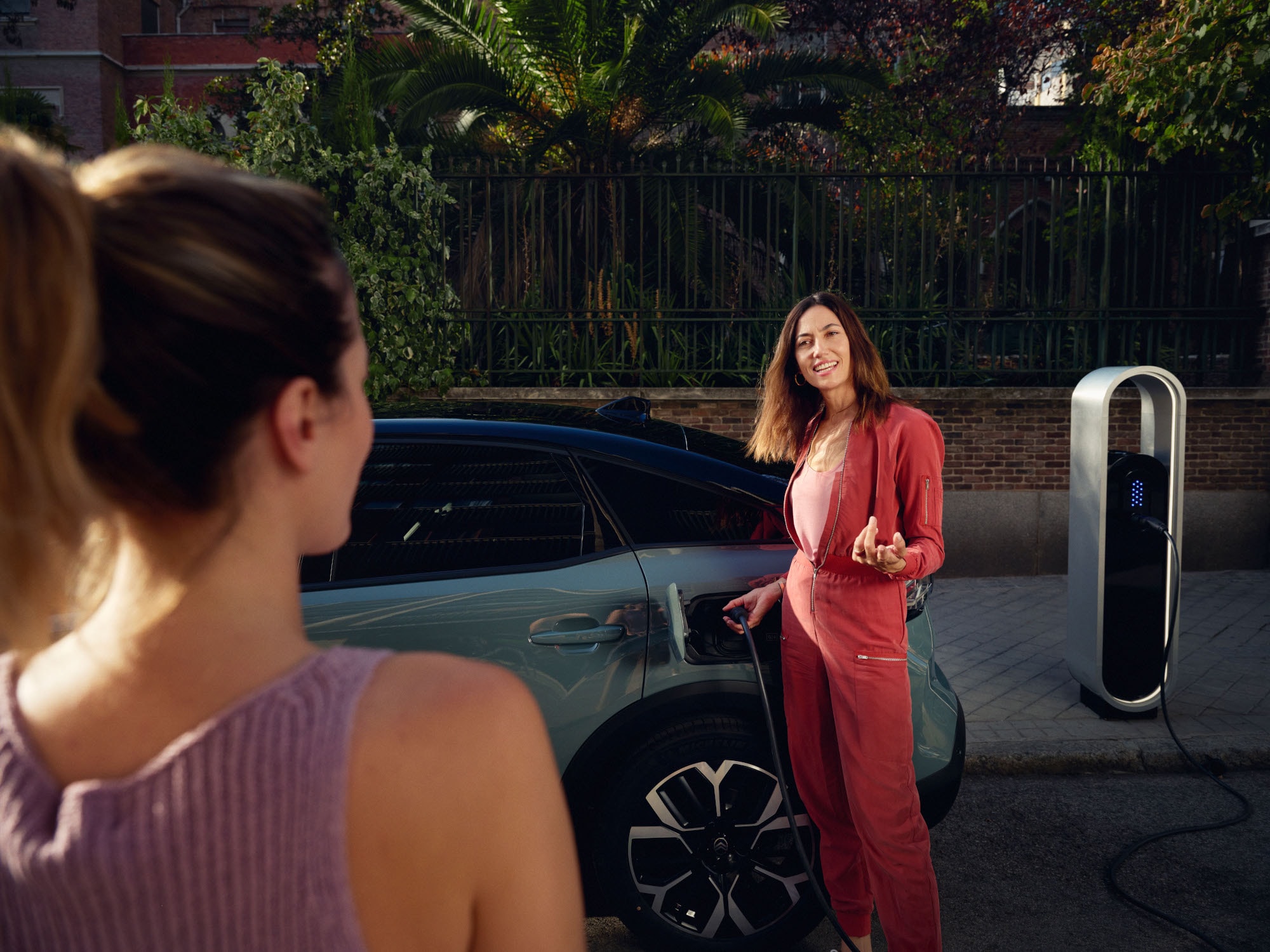 Vista trasera lateral del C4 Electric destacando carga sin esfuerzo, eficiencia, confort y diseño para un momento urbano cálido y premium.