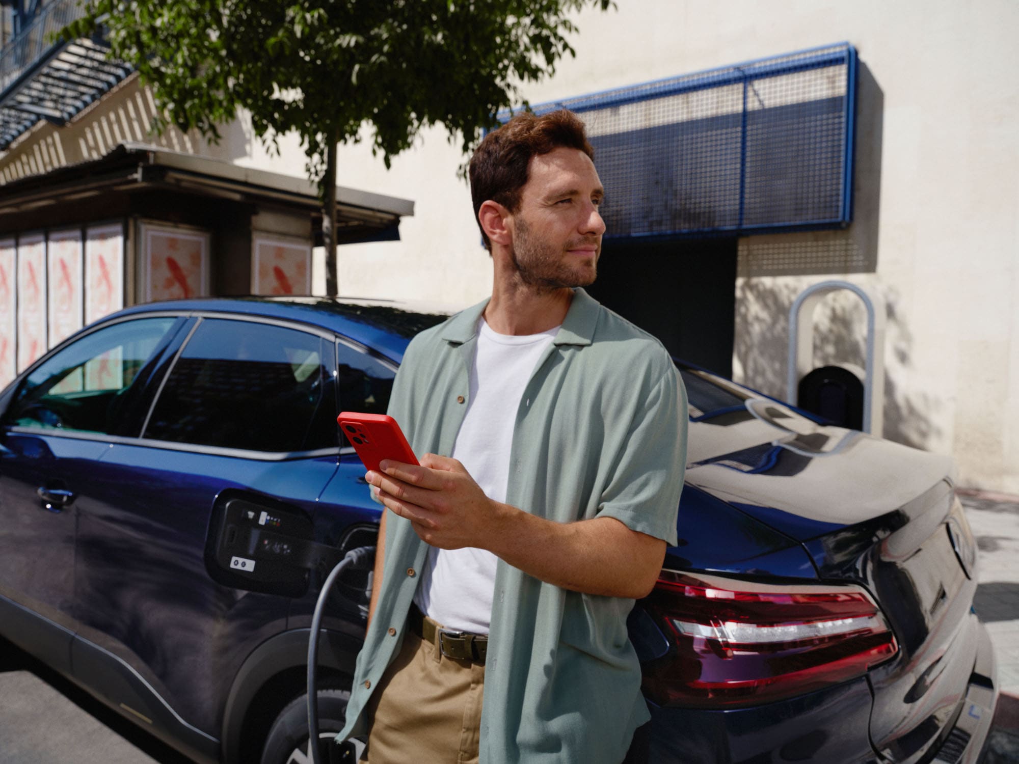 Escena de carga conectada del Citroën C4 X fastback mostrando uso de app inteligente para una movilidad eléctrica diaria conveniente.