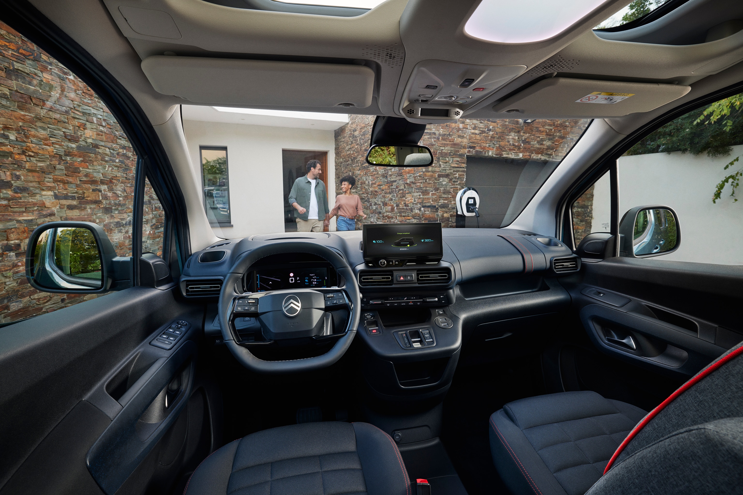 Vista interior frontal del Berlingo mostrando techo panorámico, confort, espacio, conectividad y diseño premium.