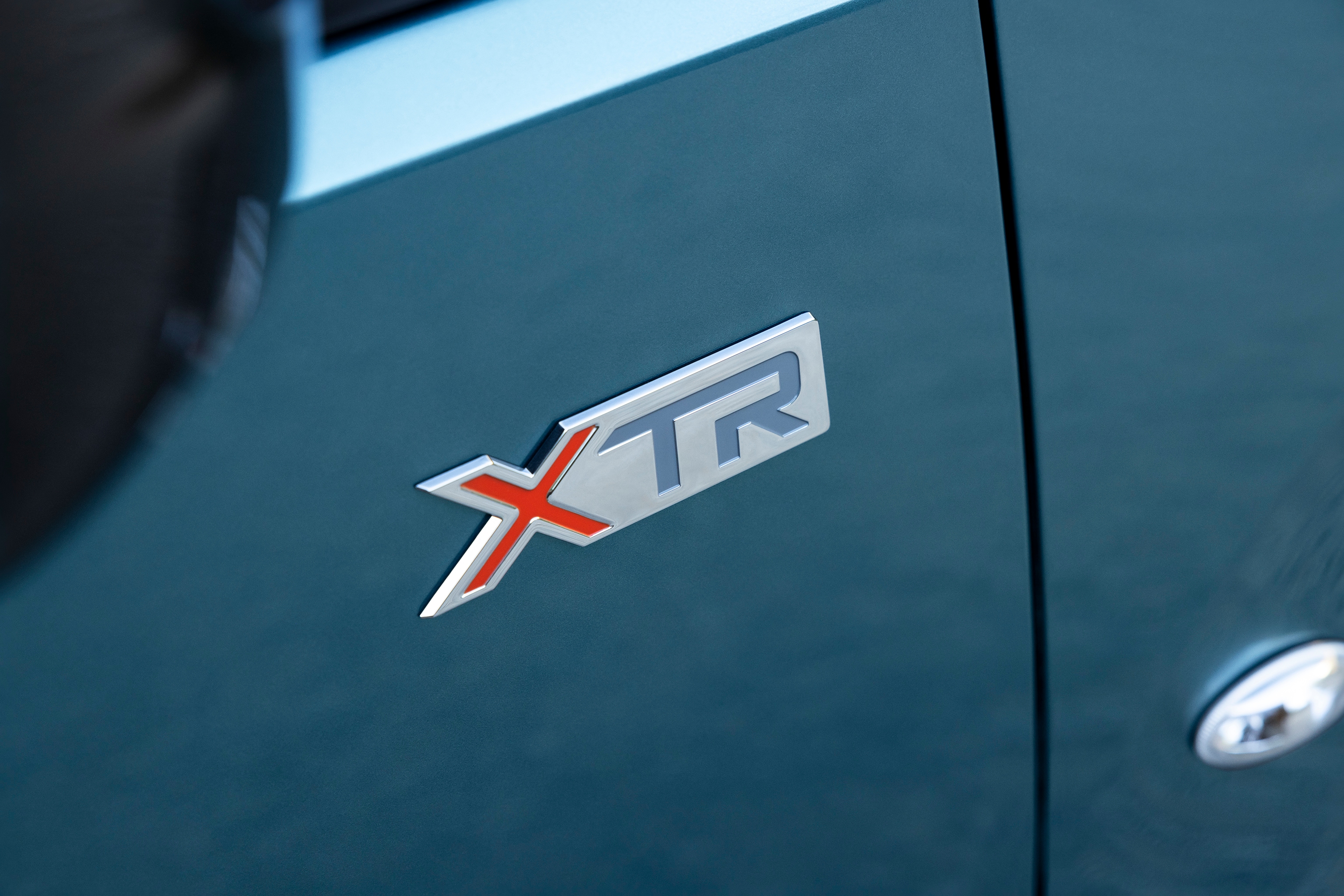 Vista detalle del emblema XTR del Berlingo destacando diseño distintivo, calidad, durabilidad e identidad de modelo mejorada