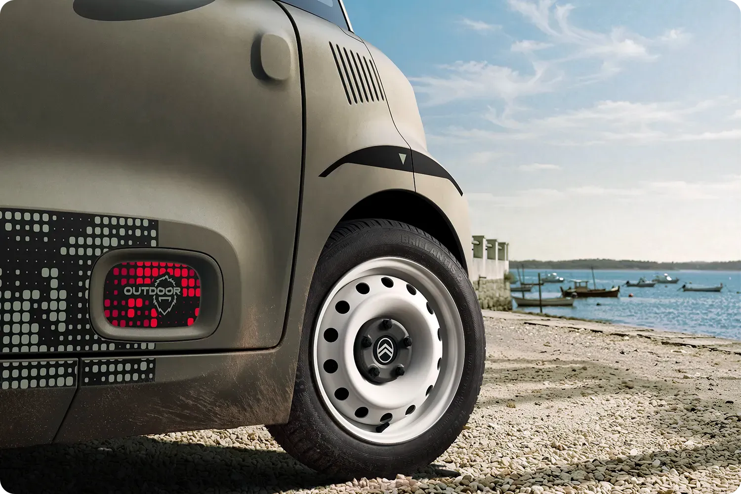 Primer plano del paso de rueda del Citroën Ami Outdoor, con un diseño compacto, eléctrico y accesible y un estilo innovador para tus aventuras junto al mar.