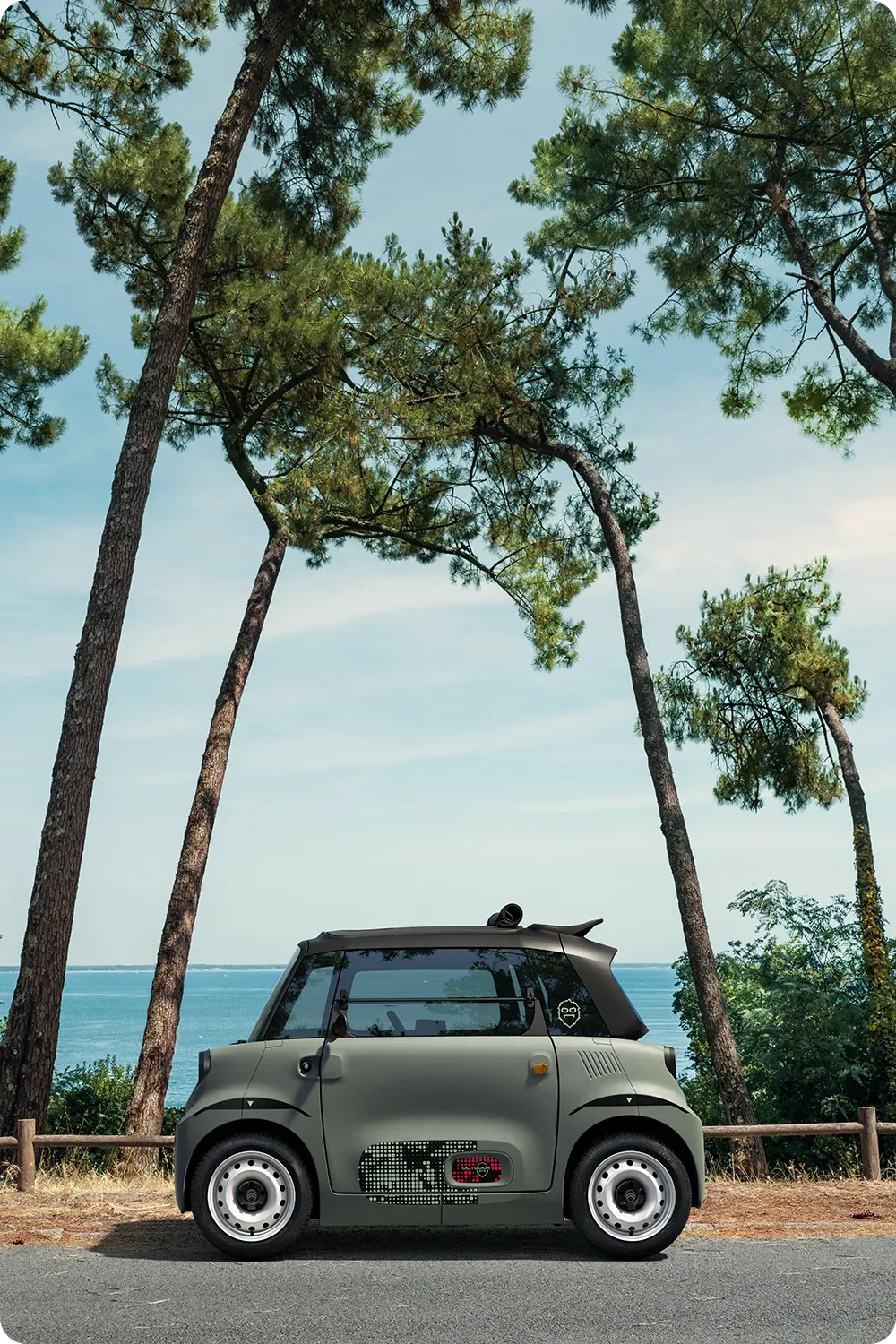Vista lateral del Citroën Ami Outdoor, un cuadriciclo compacto, eléctrico y accesible con un diseño innovador para tus desplazamientos urbanos junto al mar.