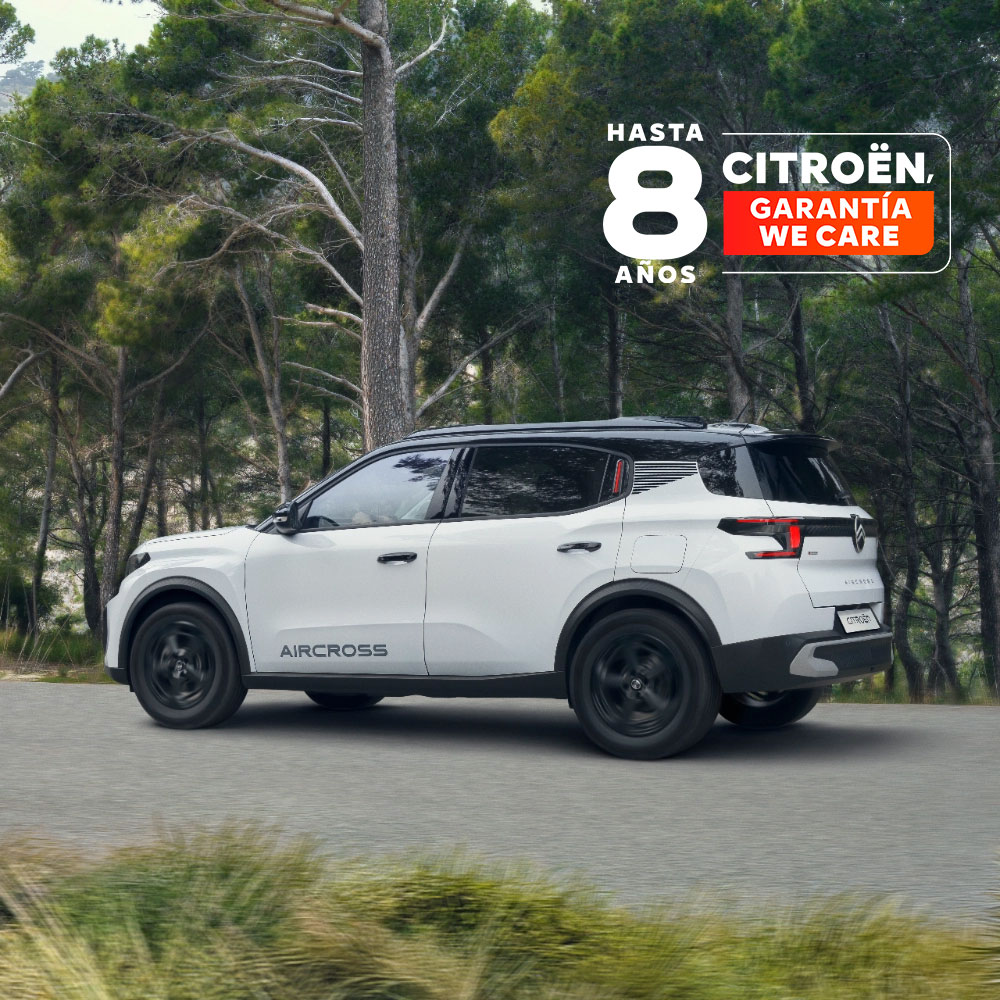 Vista trasera en tres cuartos en movimiento en un camino forestal del Citroën ë‑C3 Aircross SUV eléctrico destacando un diseño premiado y 8 años de cobertura para una movilidad asequible.